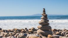 Piedras apiladas de manera equilibrada con el mar de fondo