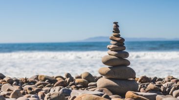 Piedras apiladas de manera equilibrada con el mar de fondo