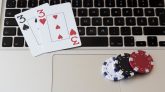 Cartas y fichas de poker encima del teclado de un portátil. Juego online