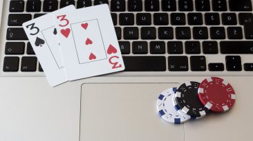 Cartas y fichas de poker encima del teclado de un portátil. Juego online